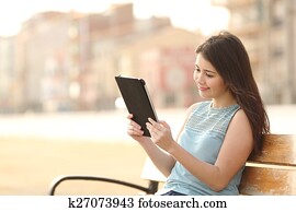 Teen student girl reading a tablet and learning