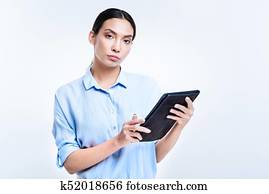 Beautiful woman in blue shirt holding a tablet