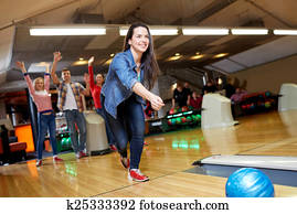 happy young woman throwing ball in bowling club happy young woman throwing ball in bowling club