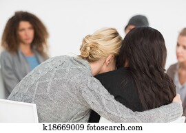 Women embracing in rehab group at therapy Women embracing in rehab group at therapy