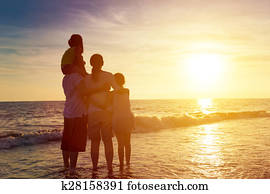 happy family watching the sunset on the beach