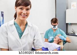 Assistant with dentistry work in the background