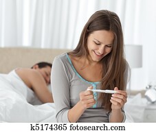 Happy woman looking a pregnancy test 