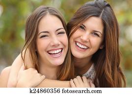 Two women friends laughing with a perfect white teeth Two women friends laughing with a perfect white teeth
