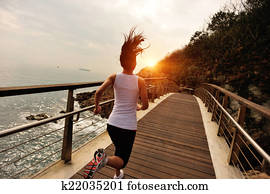 Runner athlete running on boardwalk Runner athlete running on boardwalk