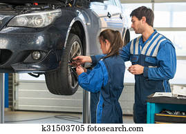 Mechanic teaching an intern in a garage