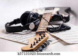 Electric guitar and headphones with music notes.