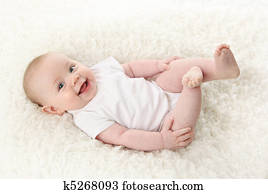 Baby lying on back smiling with feet in the air Baby lying on back smiling with feet in the air