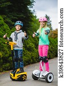 Happy kids standing on hoverboard or gyroscooter outdoor