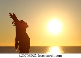 Woman breathing fresh air at sunset