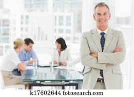 glücklich, geschäftsmann, anschauen kamera, während, personal, diskutieren, hinter, ihm, in, büro