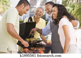 Family Enjoying A Barbeque Family Enjoying A Barbeque