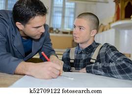 young carpenter trainee learning with mentor young carpenter trainee learning with mentor