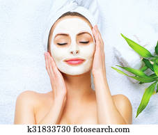 Spa woman applying facial cleansing mask