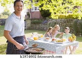 Family Enjoying A Barbeque Family Enjoying A Barbeque