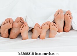  Family on the bed  at home with their feet showing