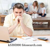 Man calculating his bills while his Man calculating his bills while his