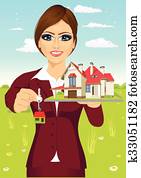 female real estate agent holding a model house