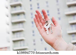 A real estate agent holding keys to a new apartment in her hands.