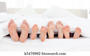 Family's feet in the bed Family's feet in the bed