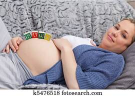 Pregnant young woman with cubes on her belly