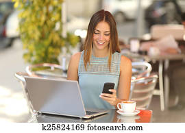 Entrepreneur working with a phone and laptop in a coffee shop Entrepreneur working with a phone and laptop in a coffee shop