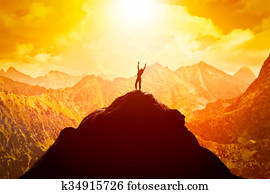 Happy woman on peak of the mountain enjoying the success, freedom and bright future.