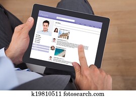 Businessman Surfing Social Networking Site On Digital Tablet Businessman Surfing Social Networking Site On Digital Tablet