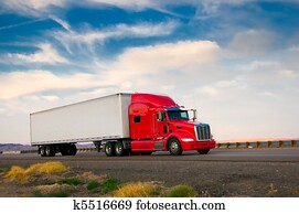 Red truck moving on a highway Red truck moving on a highway