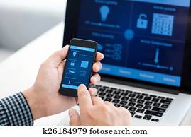 man holding phone with program smart home on the screen