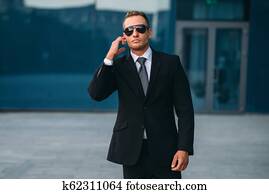 Male bodyguard in suit, earpiece and sunglasses Picture | k67301494