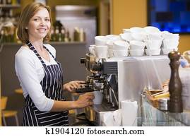 Woman making coffee in restaurant smiling Woman making coffee in restaurant smiling