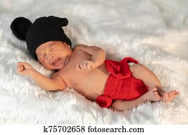 newborn baby in mouse costume crying on fur bed newborn baby in mouse costume crying on fur bed