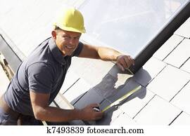 Roofer Working On Exterior Of New Home