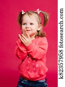 Positive little girl having fun and hiding face by hands. Positive little girl having fun and hiding face by hands.