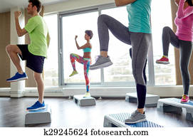group of people raising legs on step platforms group of people raising legs on step platforms