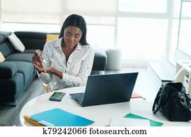 Black Woman Working From Home Using Hand Sanitizer Black Woman Working From Home Using Hand Sanitizer