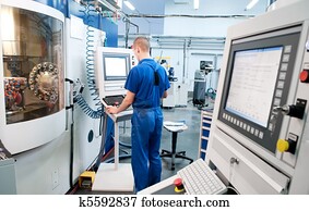 worker operating CNC machine center worker operating CNC machine center