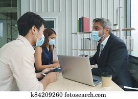 Business people wearing masks working together
