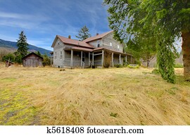 Very old rustic grey house on the country farm land.