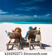 Couple relax on a beach at Maldives Couple relax on a beach at Maldives