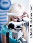 optometry concept - pretty young female patient having her eyes optometry concept - pretty young female patient having her eyes