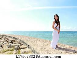 Woman relaxing at the beach with arms open enjoying her freedom