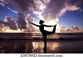 Yoga woman on the beautiful beach at sunrise