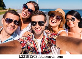 Capturing fun. Five young happy people making selfie and smiling