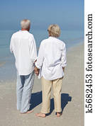 Happy Senior Couple Holdings Hands on A Tropical Beach