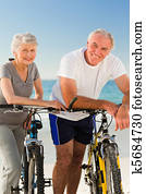Retired couple with their bikes on the beach