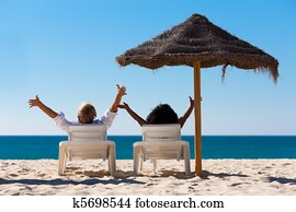 Couple on beach vacation with sunshade Couple on beach vacation with sunshade