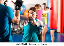 Female kick boxer with trainer in sparring Female kick boxer with trainer in sparring