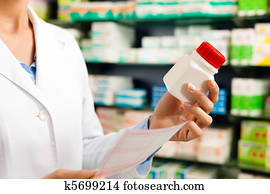 Female pharmacist in pharmacy with medicament